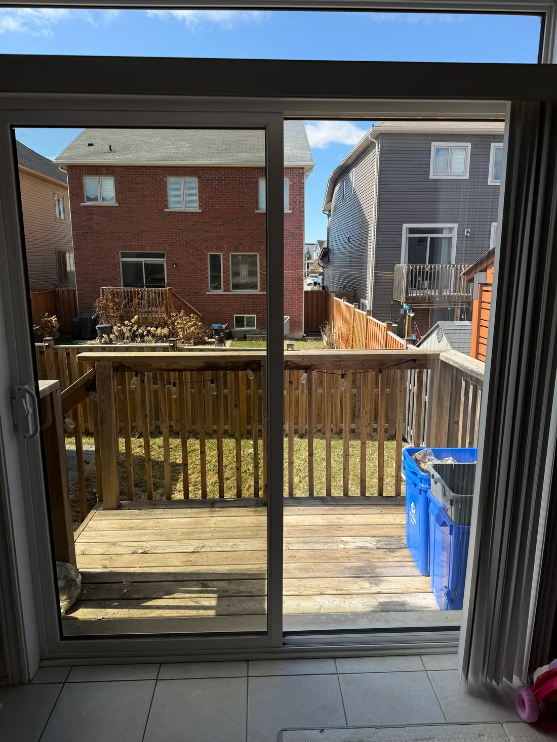A filmed sliding patio door from inside, with a clear view of the backyard.