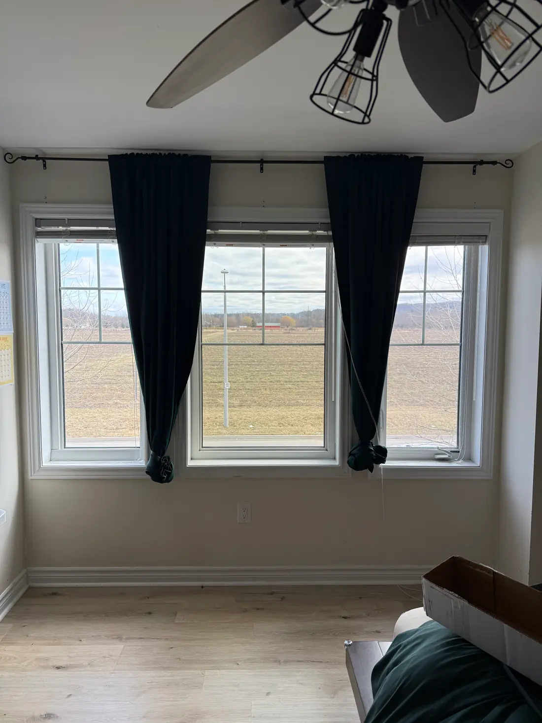 Filmed windows looking out over a field, with the view kept and glare reduced.